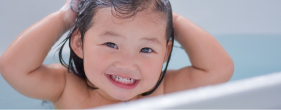 笑顔で湯船に浸かっている子ども