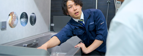 浴室の説明をしているスタッフ