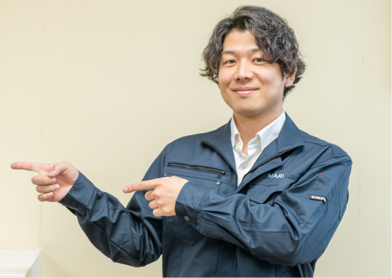 笑顔で左側を指しているスタッフ