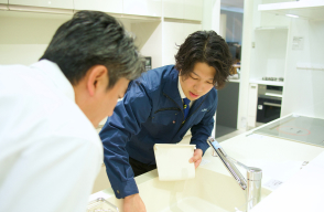 ショールームでお客様へキッチンの説明をしている
