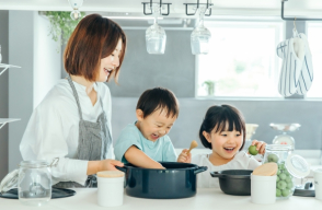 母親と子ども二人が一緒に料理する様子